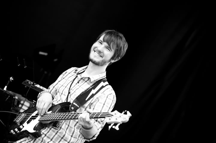Black-and-white photo of Chris Ulery smiling while playing bass