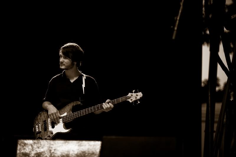 Chris Ulery playing bass on a dark stage