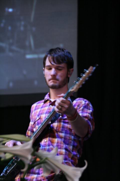 Chris Ulery playing bass in a plaid shirt
