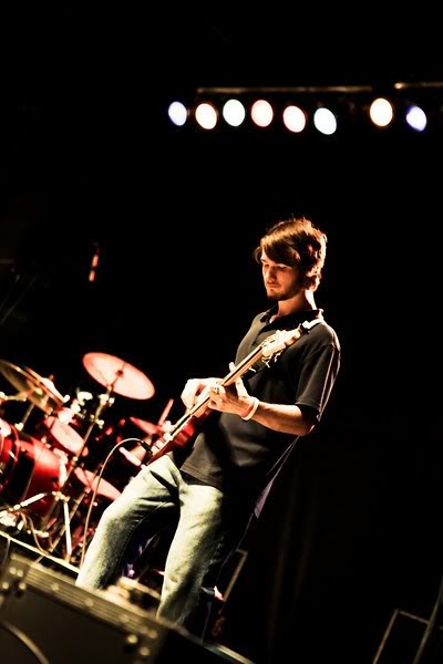 Chris Ulery playing bass under a row of stage lights