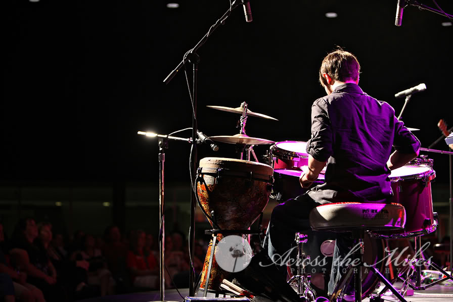 Chris Ulery playing drums and djembe at an outdoor concert in Decatur
