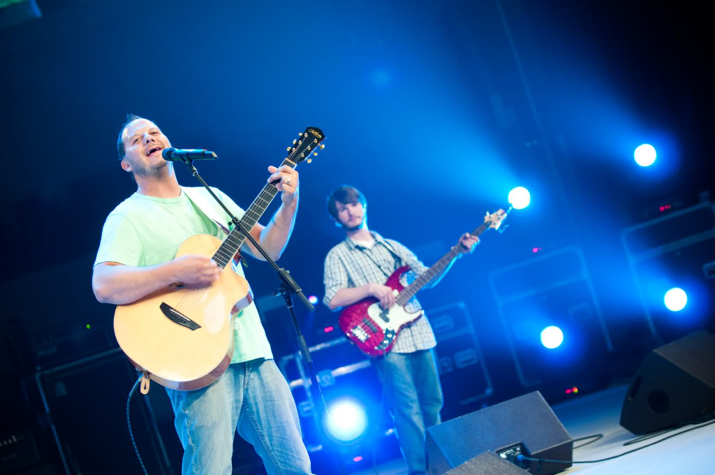 Chris Ulery playing bass beside FFH's frontman under blue stage lights