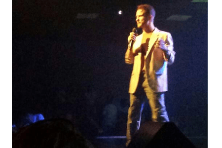 Chris Ulery preaching in a spotlight