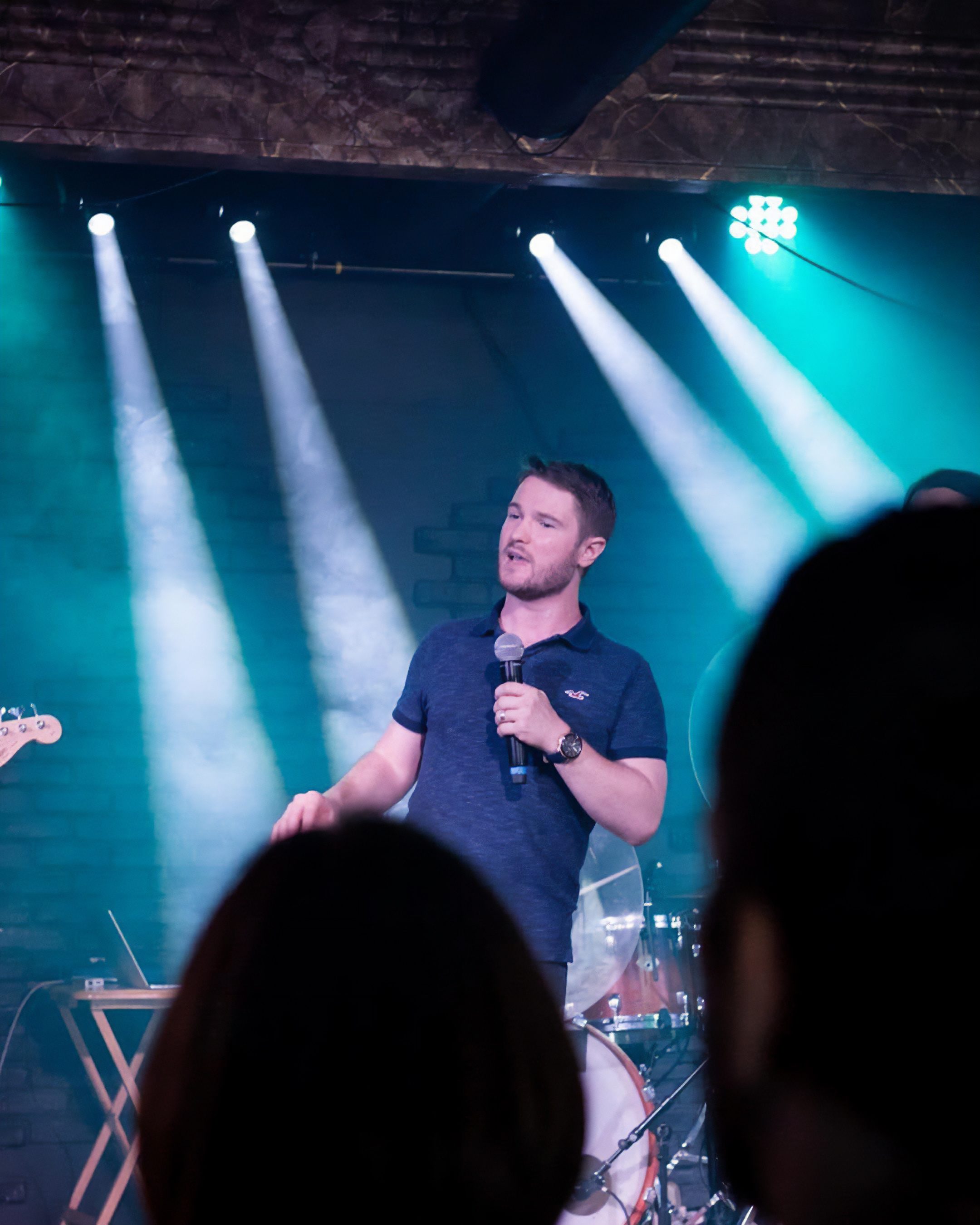 Chris Ulery preaching under teal stage lights at Victory Downtown in Tulsa