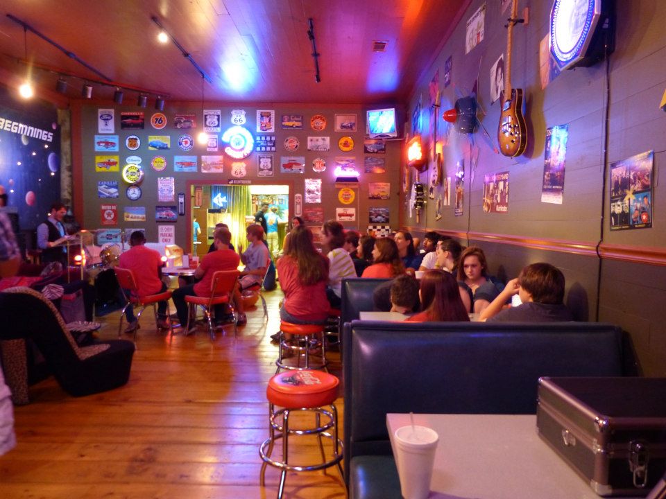 Retro youth cafe with booths and neon signs set up for a Chris Ulery event