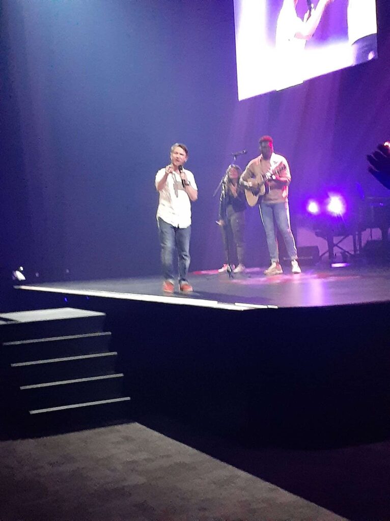 Chris Ulery speaking with the worship team on the main stage at Victory Church in Tulsa