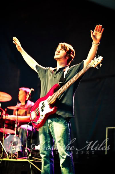 Chris Ulery raising his hands in worship while playing bass