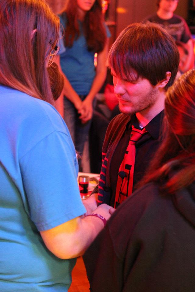 Young people praying together with hands joined at a Chris Ulery event