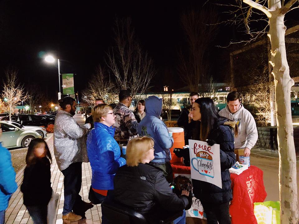A crowd gathering at a free hot chocolate outreach table