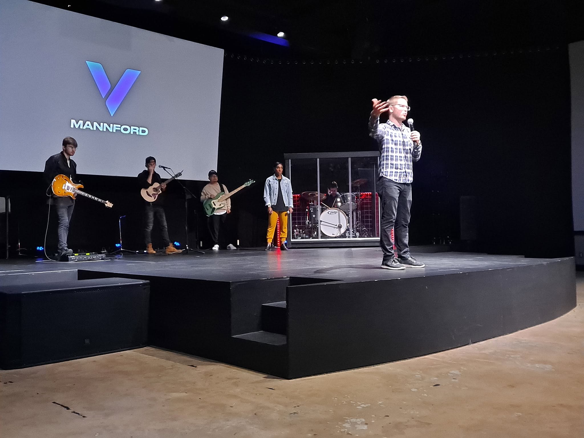 Chris Ulery preaching at Victory Mannford in Mannford, Oklahoma, with the worship team behind him